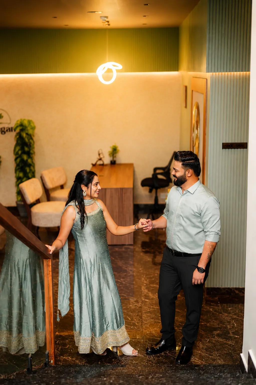 Sintomon and Sona holding hands inside a hallway